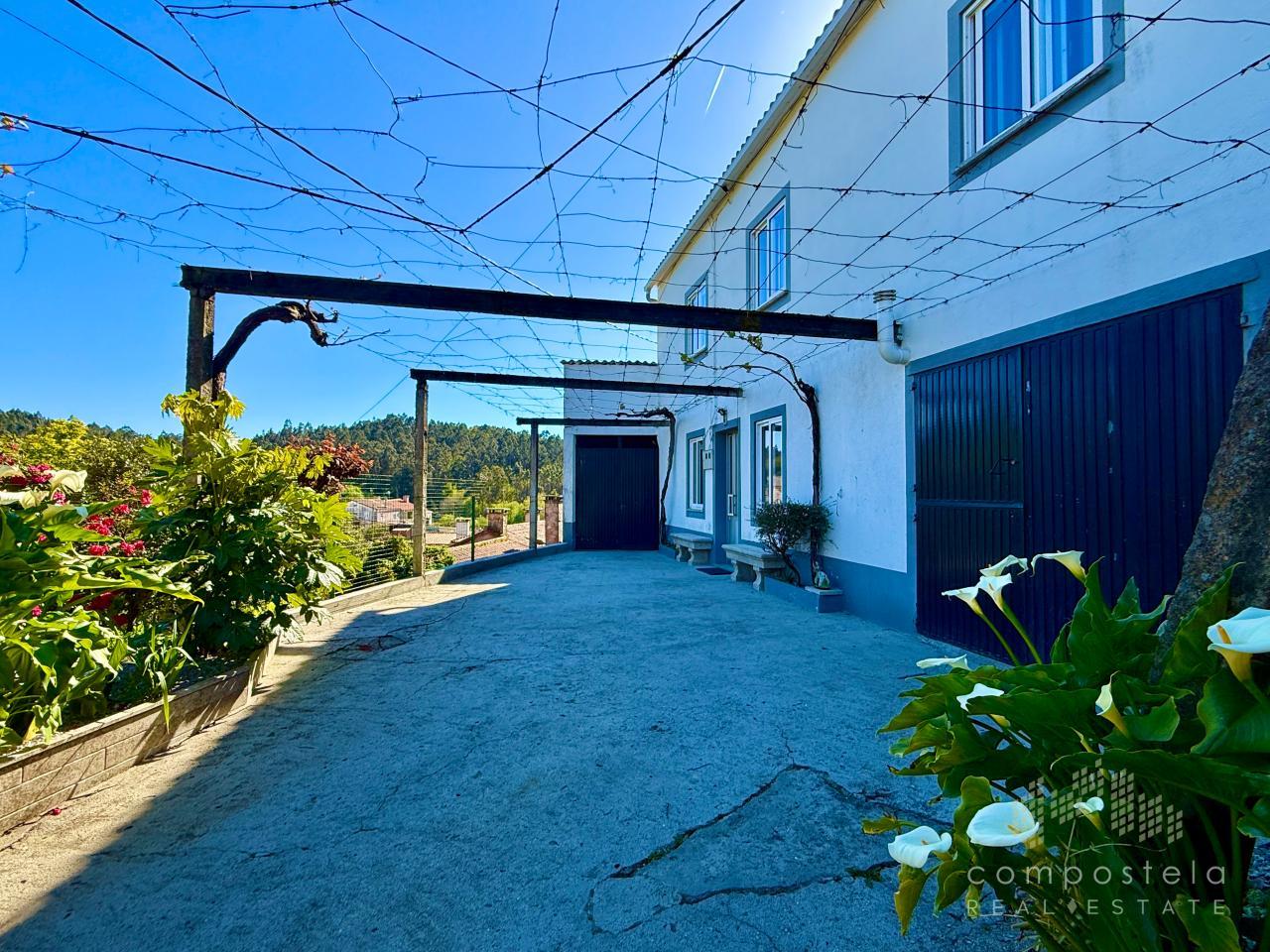 Fachada principal, garaje cerrado y alpendre cubierto